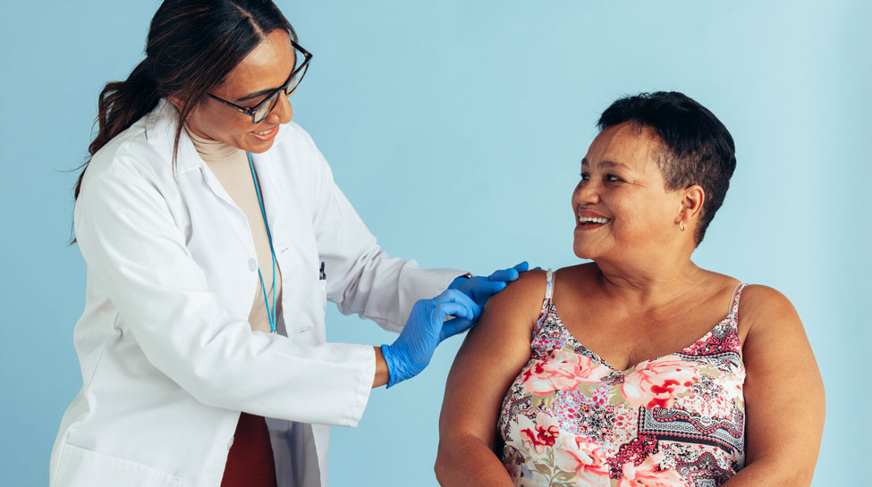 Nurse or pharmacist preparing a woman's arm for the flu shot