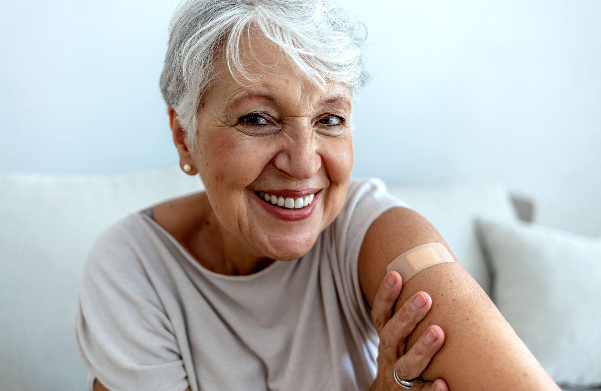 Senior woman shows where she got her flu shot